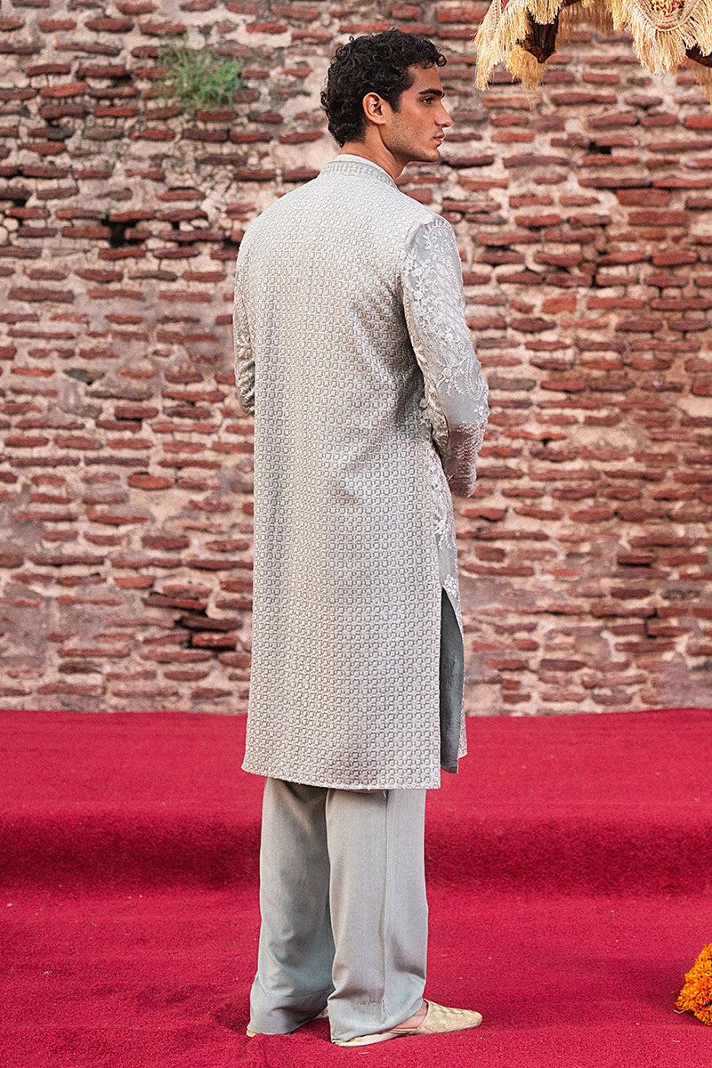Man wearing a traditional kurta with a brick wall background