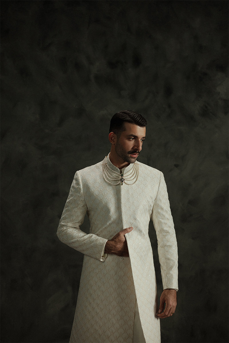 Groom’s wedding sherwani in ivory white with traditional patterns
