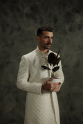 White sherwani for grooms with elegant embroidery, perfect for weddings.